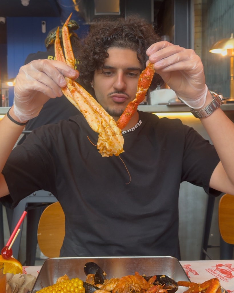 Influencer enjoying crab leg at Angry Crab Shack