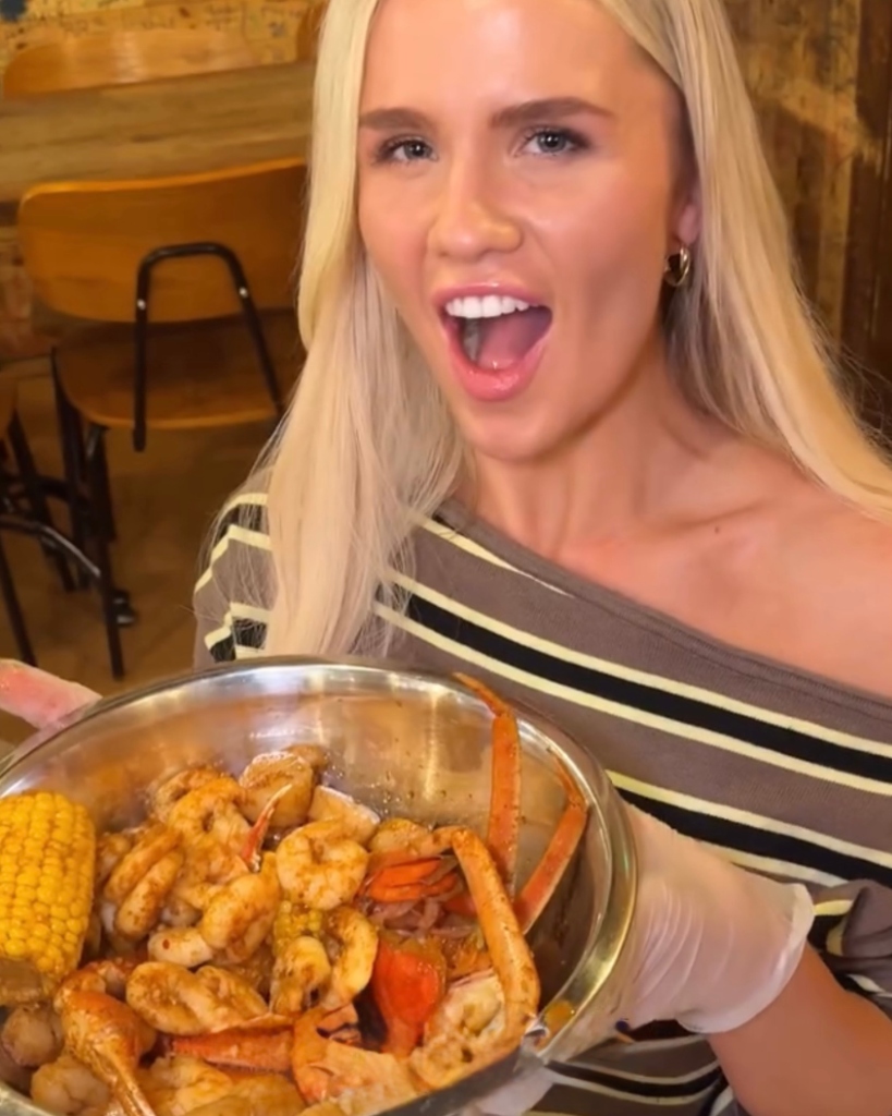 Influencer holding seafood bowl at Angry Crab Shack